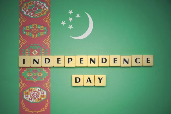 Litery z tekstu Święto Niepodległości na fladze Turkmenistanu. — Zdjęcie stockowe
