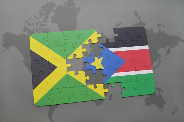 Rompecabezas con la bandera nacional de jamaica y sudan del sur en un mapa del mundo — Foto de Stock