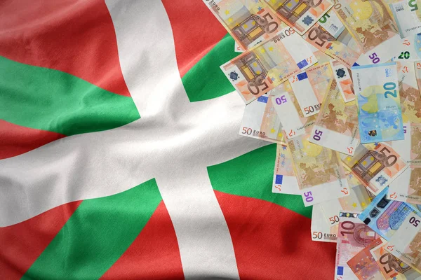 Geld eurobankbiljetten op de wapperende vlag van Baskenland. — Stockfoto