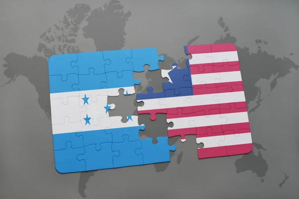 Puzzle mit der Nationalflagge von Honduras und Liberia auf einer Weltkarte — Stockfoto