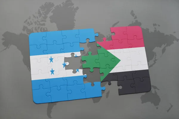 Rompecabezas con la bandera nacional de honduras y sudan en un mapa del mundo — Foto de Stock