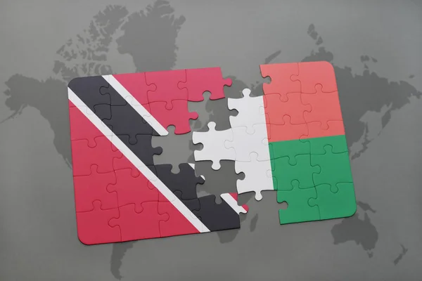 Puzzle avec le drapeau national de Trinidad et tobago et madagascar sur une carte du monde — Photo
