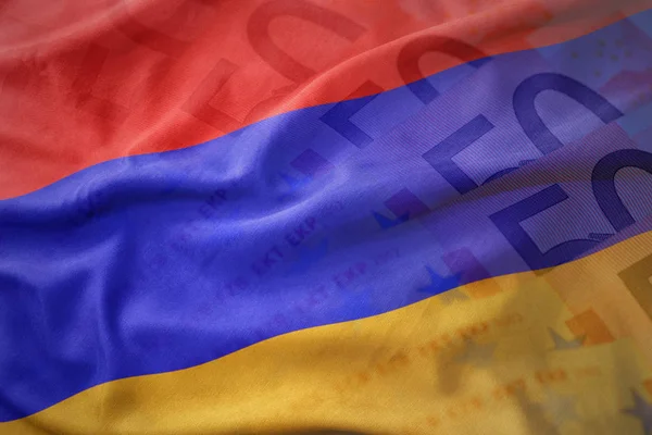 Coloré agitant le drapeau national de l'arménie sur un fond de billets en euros . — Photo