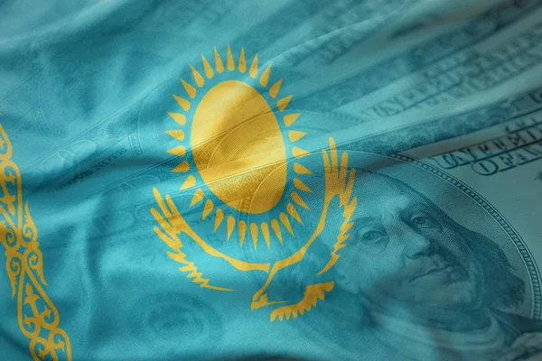 Farbenprächtig schwenkende Nationalflagge Kasachstans vor dem Hintergrund des amerikanischen Dollargeldes. Finanzierungskonzept — Stockfoto
