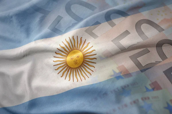 Красочные размахивая национальным флагом Аргентины на фоне банкнот евро деньги. финансовая концепция — стоковое фото