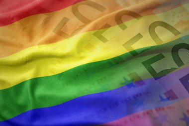renkli bir euro para banknot arka plan üzerinde gay Gökkuşağı bayrağı sallayarak. Ekonomi kavramı