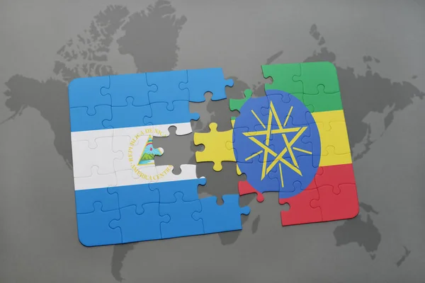 Rompecabezas con la bandera nacional de nicaragua y etiopía en un mapa del mundo — Foto de Stock