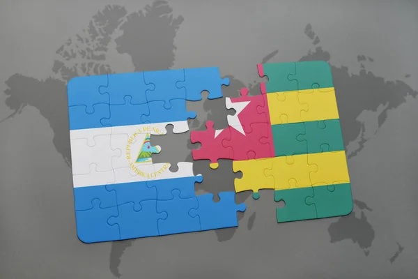 Puzzle avec le drapeau national de nicaragua et togo sur une carte du monde — Photo