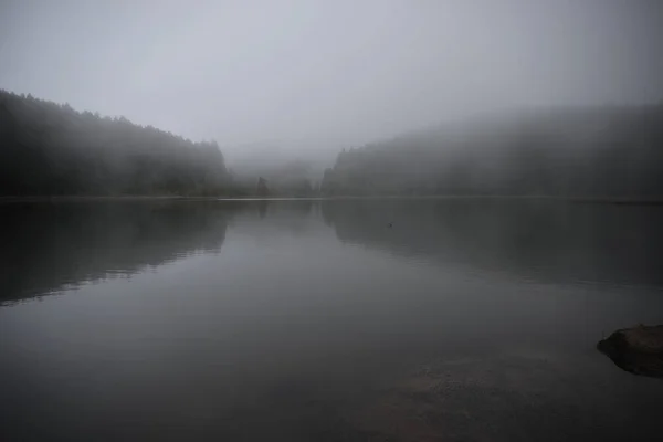 Таинственное темное озеро в утреннем тумане — стоковое фото