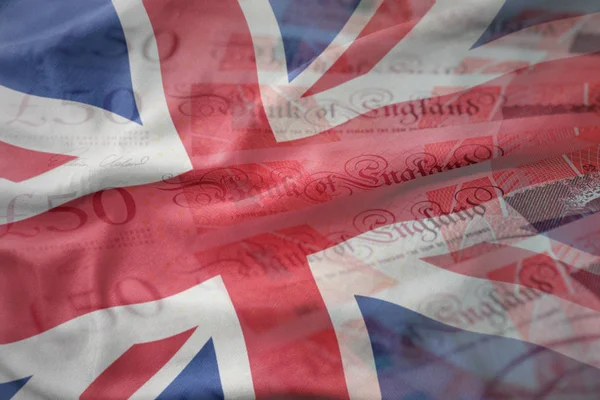 Coloré agitant drapeau national de grand britain sur un fond de billets d'argent livres. concept de financement — Photo