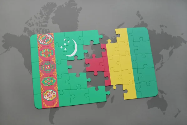 Puzzle con la bandiera nazionale del turkmenistan e ghinea su una mappa del mondo — Foto Stock