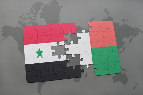 Puzzel met de nationale vlag van Syrië en Madagaskar op een wereldkaart — Stockfoto