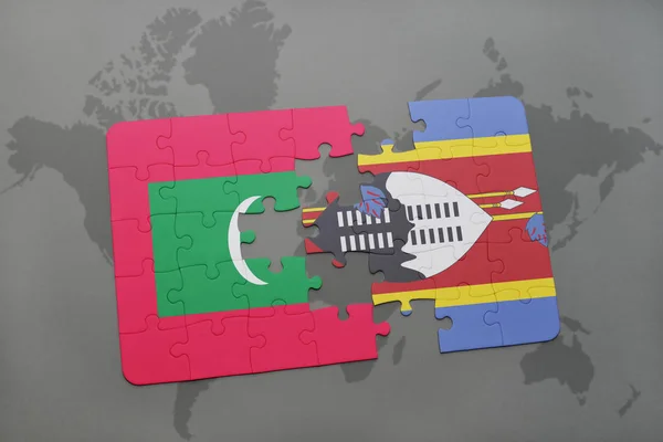 Головоломка с национальным флагом Мальдив и Свазиленда на карте мира — стоковое фото