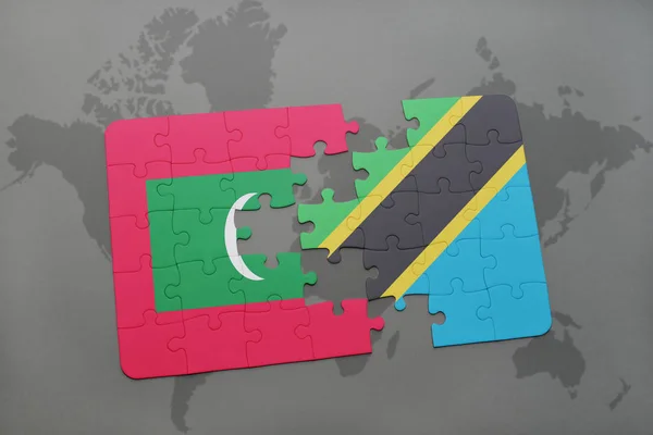 Puzzle mit der Nationalflagge der Malediven und Tansanias auf einer Weltkarte — Stockfoto