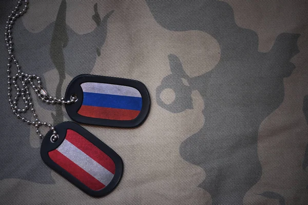 Армія порожнім, собака тег з прапором Росії та Австрії на фоні хакі текстури. Військова концепція — стокове фото