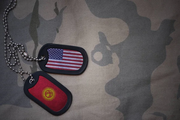 Армія порожнім, собака тег з прапором США та Киргизстан на фоні хакі текстури. Військова концепція — стокове фото