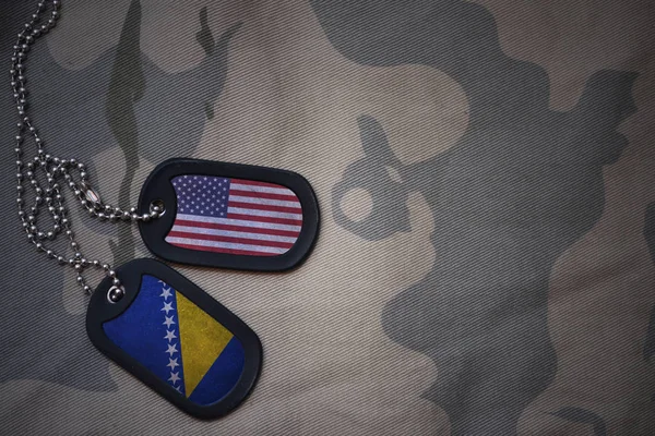 Армія порожнім, собака тег з прапором США та Боснія і Герцеговина на фоні хакі текстури. Військова концепція — стокове фото