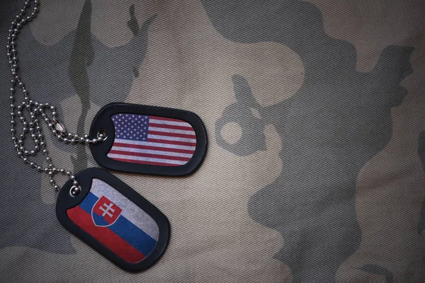 Leger leeg, dog tag met de vlag van de Verenigde Staten van Amerika en Slowakije op de achtergrond van de kaki textuur. militair concept — Stockfoto