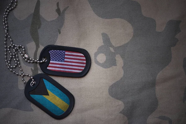Армія пуста, собача мітка з прапором об'єднаних держав америки і багам на тлі текстури хакі. військова концепція — стокове фото
