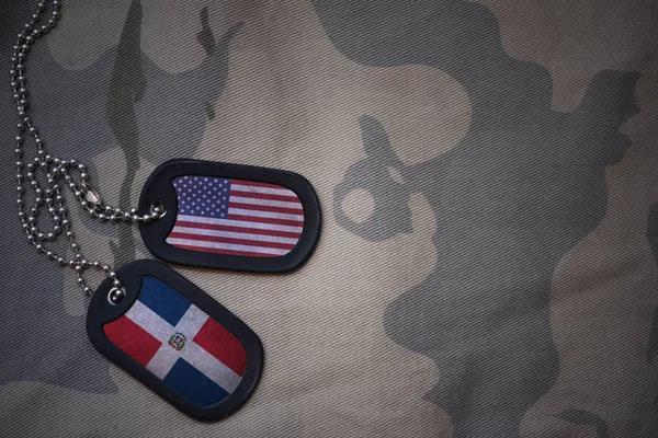 Ejército en blanco, etiqueta de perro con la bandera de los estados unidos de América y la república dominicana en el fondo de textura caqui. concepto militar — Foto de Stock