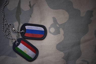 Ordu boş, köpek etiketi ile Rusya ve Tacikistan bayrağı haki doku arka plan üzerinde. askeri kavram
