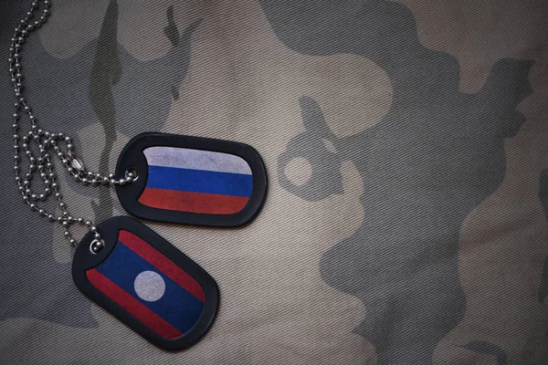 Армія пуста, тег собаки з прапором Росії і лаосу на тлі текстури хакі. військова концепція — стокове фото