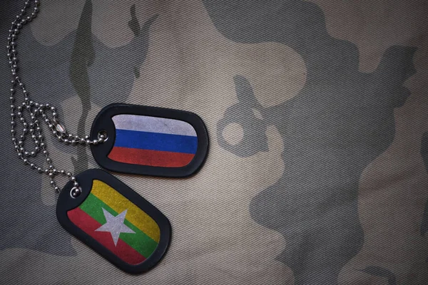 Армія порожнім, собака тег з прапор Росії і М'янмою на фоні хакі текстури. Військова концепція — стокове фото