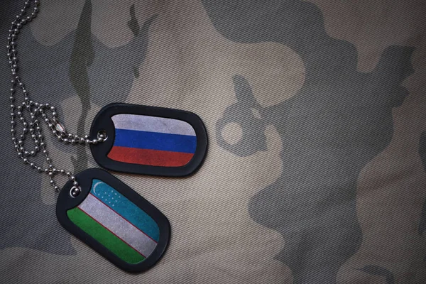 Армія порожнім, собака тег з прапором Росії і Узбекистані на фоні хакі текстури. Військова концепція — стокове фото