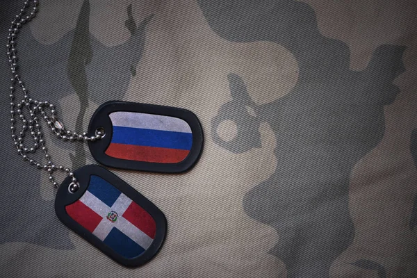 Армія пуста, тег собаки з прапором Росії і домініканської республіки на тлі текстури хакі. військова концепція — стокове фото