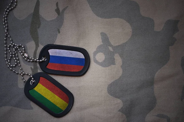 Армія порожнім, собака тег з прапором Росії та Болівії на фоні хакі текстури. Військова концепція — стокове фото