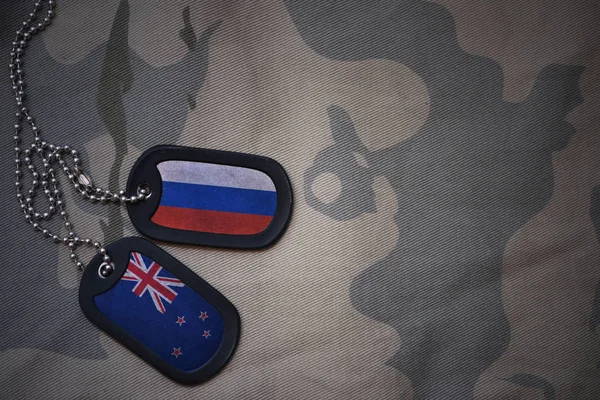 Армія пуста, собача мітка з прапором Росії та новою зеландією на тлі текстури хакі. військова концепція — стокове фото