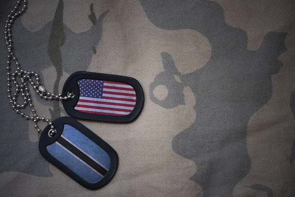 Ejército en blanco, etiqueta de perro con bandera de estados unidos de América y Botswana en el fondo de textura caqui. concepto militar — Foto de Stock