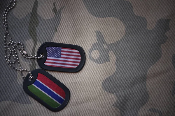 Army blank, dog tag with flag of united states of america and gambia on the khaki texture background. military concept — Stock Photo, Image