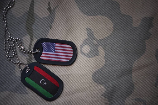 Армія пуста, тег собаки з прапором об'єднаних держав Америки та лівії на тлі текстури хакі. військова концепція — стокове фото
