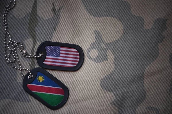 Exército em branco, tag cão com bandeira dos estados unidos da América e namibia no fundo textura cáqui. conceito militar — Fotografia de Stock