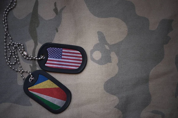 Hær blank, hund tag med flag af USA og seychelles på khaki tekstur baggrund. militært koncept - Stock-foto