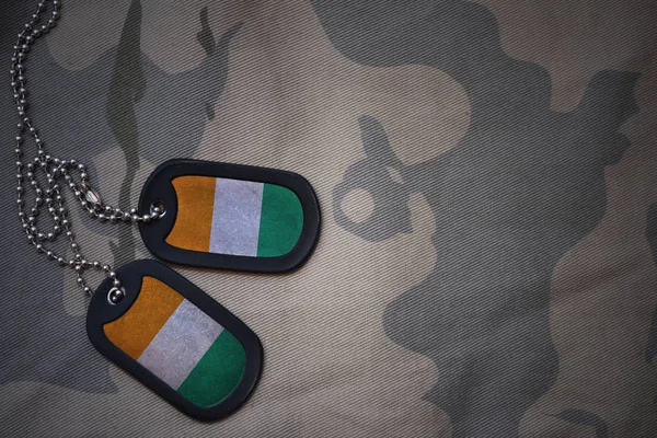 Esercito vuoto, dog tag con bandiera di cote divoire sullo sfondo texture kaki. concetto militare — Foto Stock