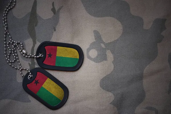 Leger leeg, dog tag met vlag van Guinee-bissau op de achtergrond van de kaki textuur. militair concept — Stockfoto