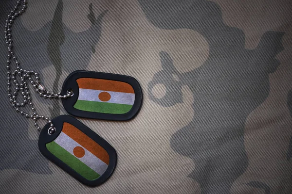 Ejército en blanco, etiqueta de perro con bandera de niger en el fondo de textura caqui. concepto militar —  Fotos de Stock