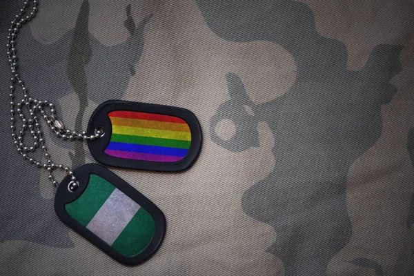 空軍、ナイジェリアとゲイの虹の旗を持つ犬タグはカーキ色テクスチャ背景のフラグです。ミリタリー コンセプト — ストック写真
