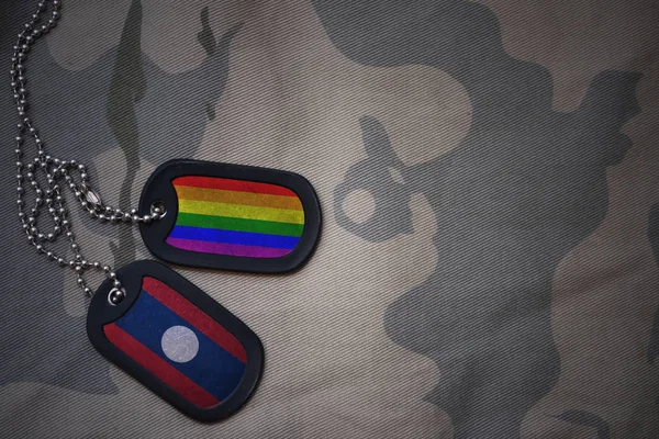 空軍、ラオスとゲイの虹の旗を持つ犬タグはカーキ色テクスチャ背景のフラグです。ミリタリー コンセプト — ストック写真