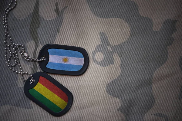 Армія пуста, тег собаки з прапором Аргентини та Болівії на тлі текстури хакі. військова концепція — стокове фото