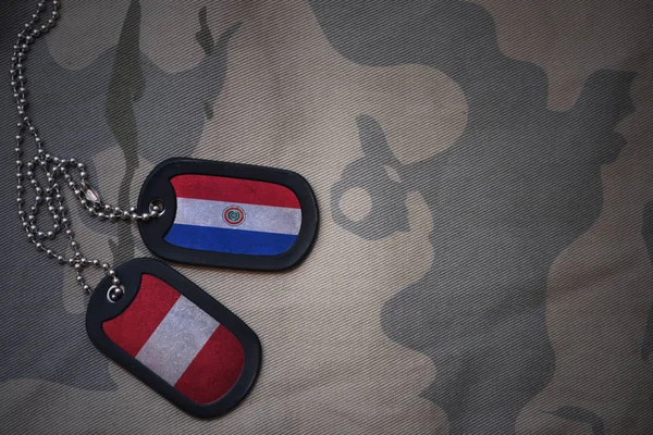 Армія пуста, тег собаки з прапором парагваю і перу на тлі текстури хакі. військова концепція — стокове фото
