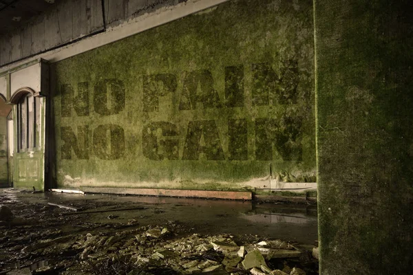 Text kein Schmerz kein Gewinn an der schmutzigen Wand eines verlassenen, zerstörten Hauses — Stockfoto