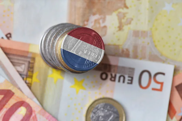 Euromynt med flagga Nederländerna på euron pengar sedlar bakgrunden. — Stockfoto