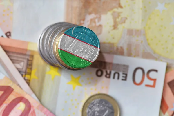 Moneda en euros con bandera nacional de Uzbekistán sobre el fondo de los billetes en euros . — Foto de Stock