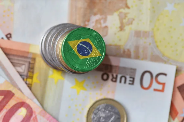 Euro coin with national flag of brazil on the euro money banknotes background. — Stock Photo, Image