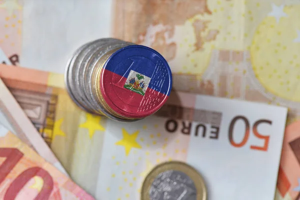 Монета евро с национальным флагом Гаити на фоне банкнот евро . — стоковое фото