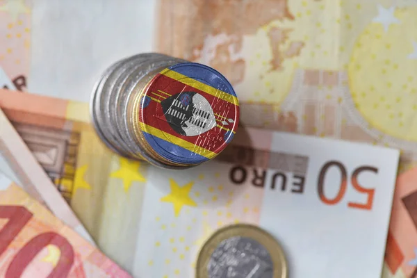 Euro coin with national flag of swaziland on the euro money banknotes background. — Stock Photo, Image