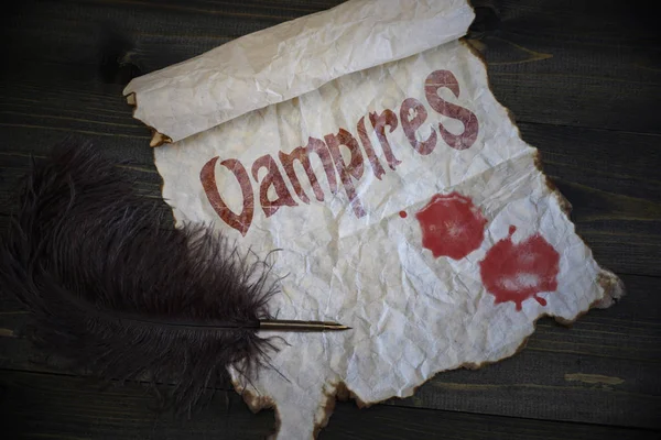 Текстові вампіри і краплі крові на старовинному папері зі старою ручкою на дерев'яному столі текстури — стокове фото